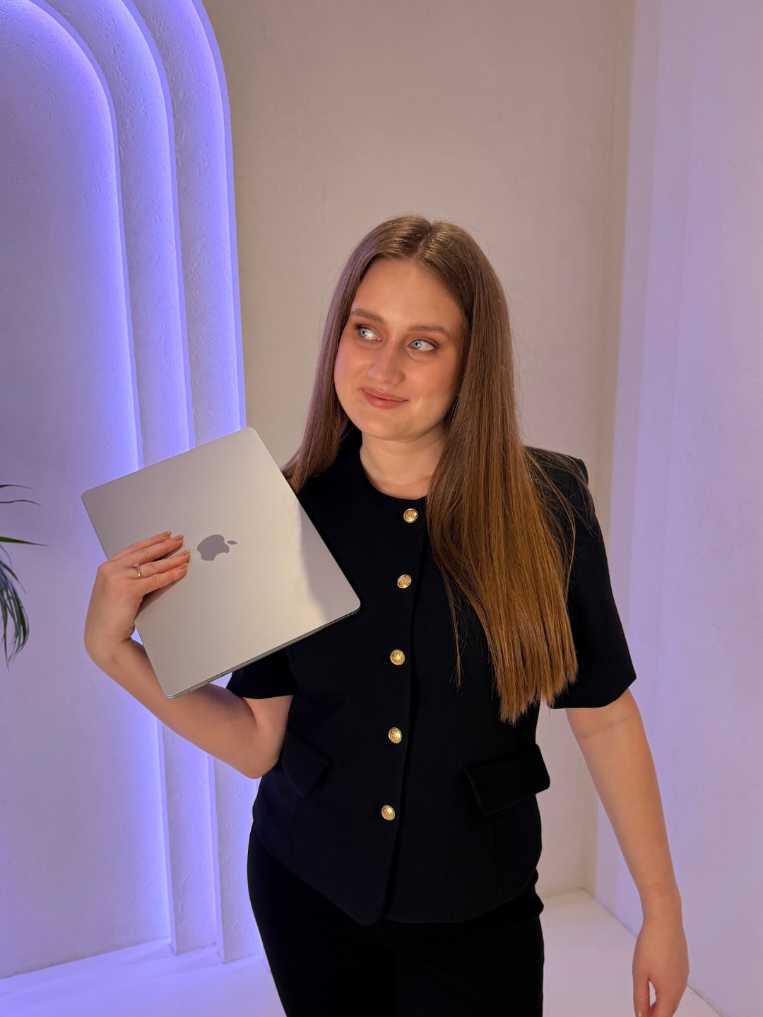 Wiktoria Pomorska z laptopem na ramieniu, w czarnym komplecie, w jasnym studiu